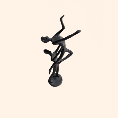 Abstract black sculpture of two figures dancing.