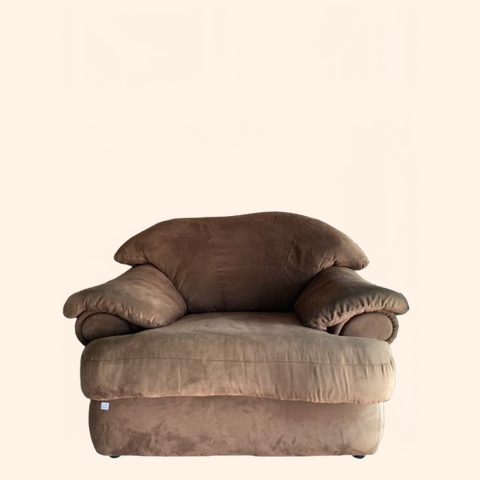 Brown, plush armchair with large, soft armrests.