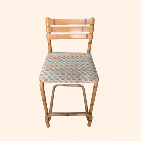 Cane lookalike PVC bar chair with patterned fabric seat cushion.