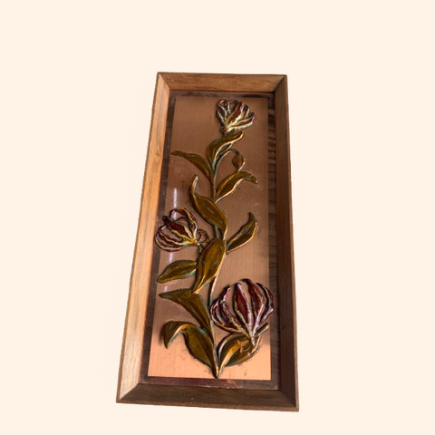 Copper wall decor featuring embossed flowers and leaves.