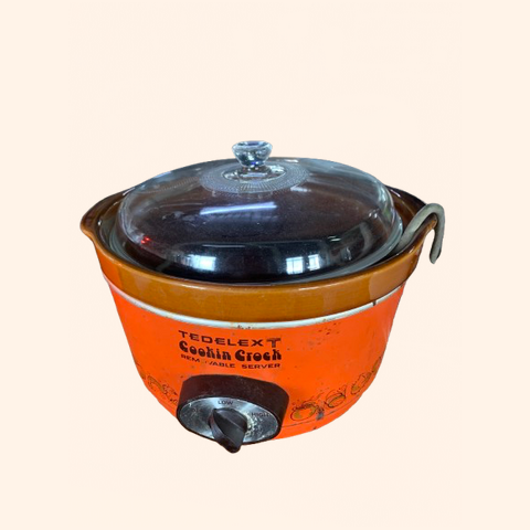 Orange electric slow cooker with a glass lid.