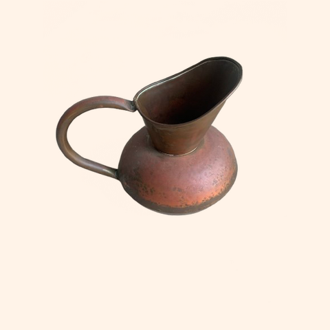 Rustic metal pitcher with a curved spout and handle.