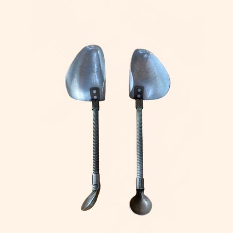 Two metal shoehorns with curved handles.