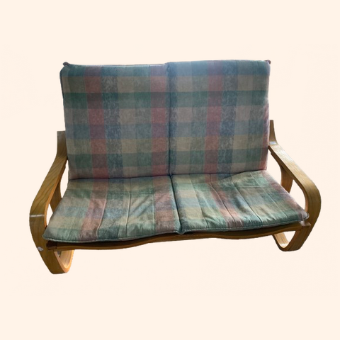 Wooden loveseat with plaid cushions.