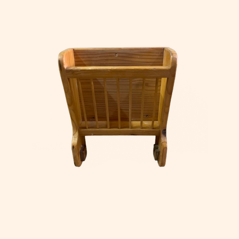 Wooden magazine holder with slatted sides and curved legs.