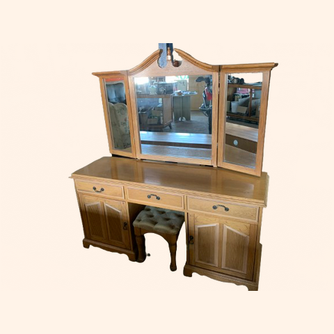 Wooden vanity with three mirrors and a matching stool.