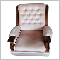 Vintage armchair with tufted upholstery and wooden armrests.