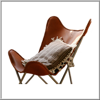 Stylish brown leather butterfly chair with a decorative pillow.