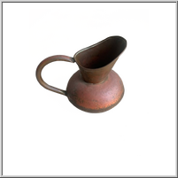 Rustic metal pitcher with a curved spout and handle.