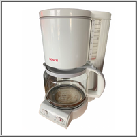 White coffee maker with a glass carafe and water gauge.